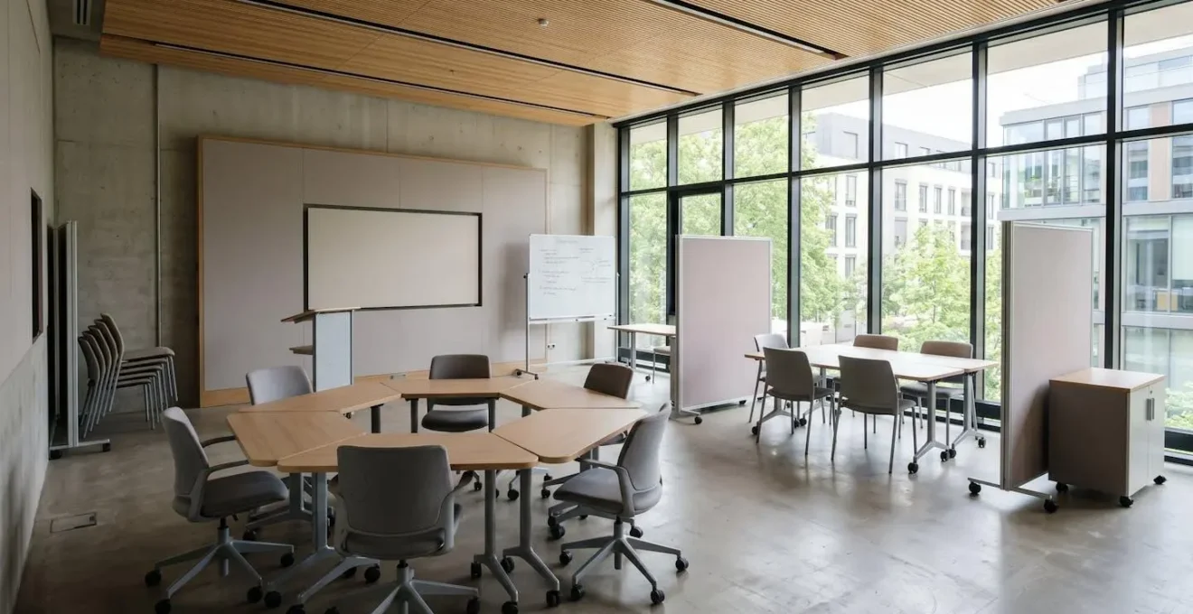 Salle de séminaire moderne avec espaces modulables et grandes baies vitrées, aménagée pour faciliter les interactions de groupe
